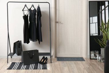 Modern salonun içinde, askılık ve kadın kıyafetleri var.