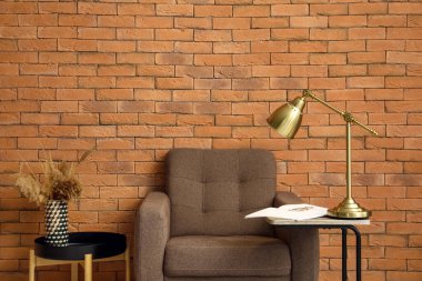 Yumuşak koltuklu, sehpalı ve tuğladan duvarı olan modern oturma odasının içinde.