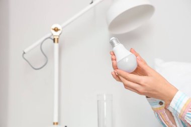 Yatak odasında ampulü olan kadın, yakın plan.