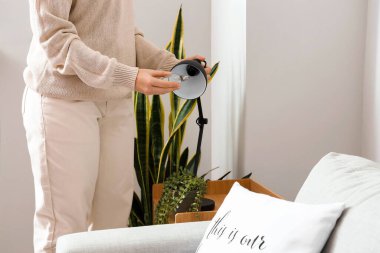 Evde ampulü siyah lambayla değiştiren kadın.