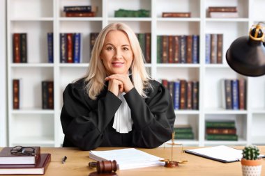 Mahkeme masasında oturan olgun kadın yargıç.