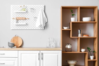 Ahşap raf ünitesi ve tahta tahtasıyla aydınlık mutfağın içinde.