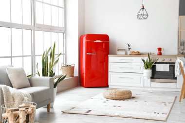 Kırmızı buzdolabı ve beyaz tezgahlı modern mutfak.