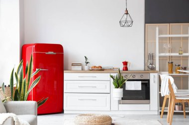 Kırmızı buzdolabı ve beyaz tezgahlı modern mutfak.