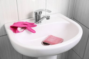 Tuvalette sünger ve lastik eldiven olan modern lavabo.