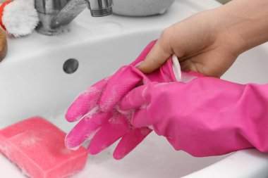 Banyoda lastik eldiveni çıkaran kadın, yakın plan.