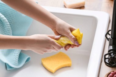 Seramik lavabonun yanında mendil sıkan kadın, yakın plan.