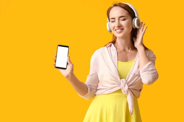 Νεαρή Κοκκινομάλλα Γυναίκα Ακουστικά Κινητό Τηλέφωνο Κίτρινο Φόντο — Φωτογραφία Αρχείου