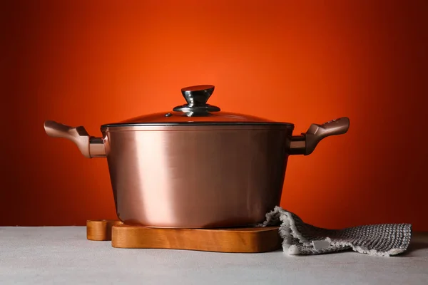 Panela Cobre Com Placa Guardanapo Mesa Contra Fundo Vermelho — Fotografia de Stock