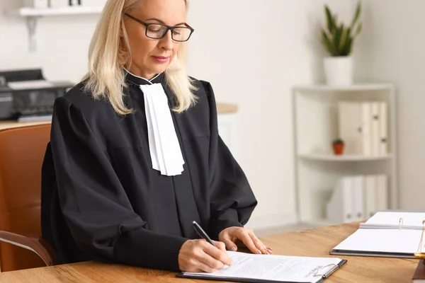 成熟した女性裁判官は法廷のテーブルで文書を扱う — ストック写真
