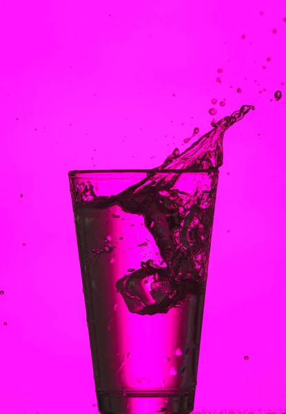 Bicchiere Acqua Limpida Con Spruzzi Sfondo Colori — Foto Stock