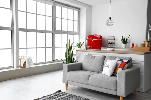 Kırmızı buzdolabı, tezgah ve kanepesi olan modern mutfak.