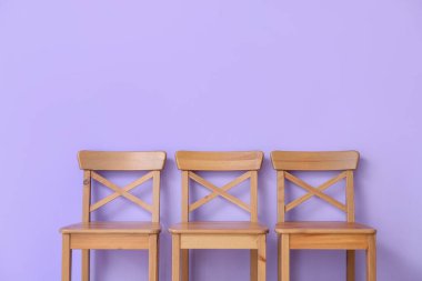 Menekşe duvarın yanındaki tahta sandalyeler.