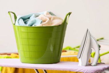 Çamaşır sepeti ve elektrikli ütü.