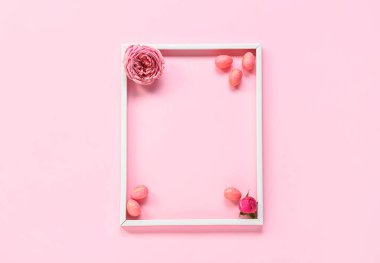 Çerçeveli güzel kompozisyon, pembe arka planda Paskalya yumurtaları ve çiçekler