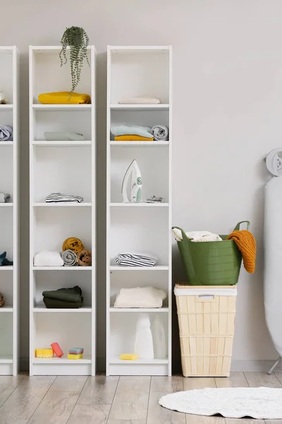 Shelf Unit Dengan Pakaian Dan Keranjang Dekat Dinding Cahaya Ruang — Stok Foto