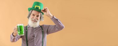 Yeşil şapkalı ve bej arka planda bir bardak biralı son sınıf öğrencisi. Mesaj için yeri var. Aziz Patrick Günü kutlaması