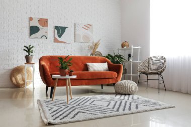 Modern oturma odasının içinde çiçekli turuncu kanepe.