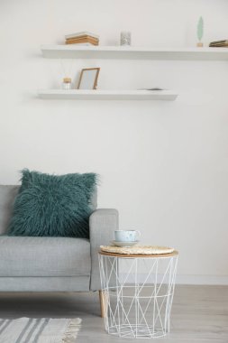 Modern oturma odasında masası olan şık gri bir kanepe.