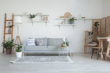 Modern oturma odasının içinde şık gri bir kanepe.