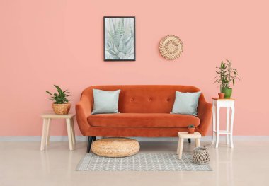 Modern oturma odasının içinde çiçekli turuncu kanepe.
