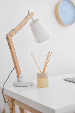 Aroma kamış ayırıcı. Masada lamba var.