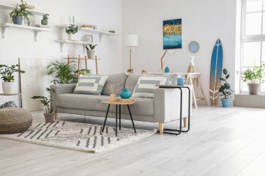 Modern oturma odasının içinde şık gri bir kanepe.