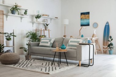 Modern oturma odasının iç kısımlarında çiçekli şık gri kanepe.