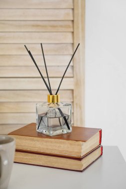 Aroma sazlık ayırıcı ve masadaki kitaplar.