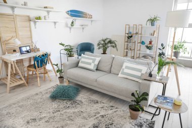 Modern oturma odasının iç kısımlarında çiçekli şık gri kanepe.