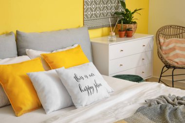 Sarı duvarlı modern yatak odasının şık iç mimarisi.