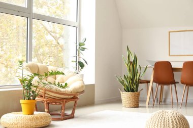 Büyük pencereli ve çiçekli aydınlık oturma odasının içi