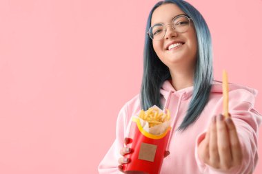 Sıra dışı saçları olan genç bir kadın ve bir paket patates kızartması.
