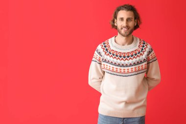 Renkli süveter giyen yakışıklı bir genç.