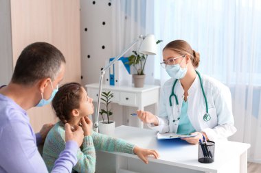 Babası hasta küçük kızıyla birlikte kliniğe doktor ziyaretinde.