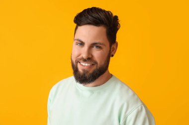 Sarı arka planda şık sakallı adam.