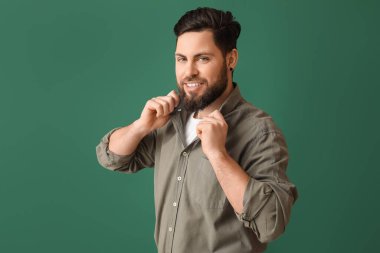 Yeşil arka planda şık sakallı adam.