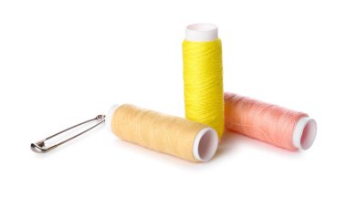 Beyaz arkaplanda iplik makaraları ve çengelli iğne