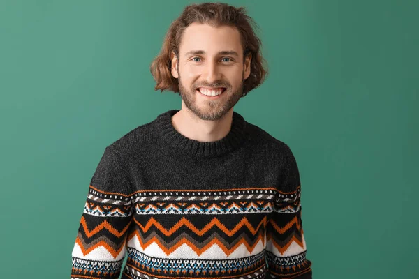 ハンサムな若いです男でニットセーター上の色の背景 — ストック写真
