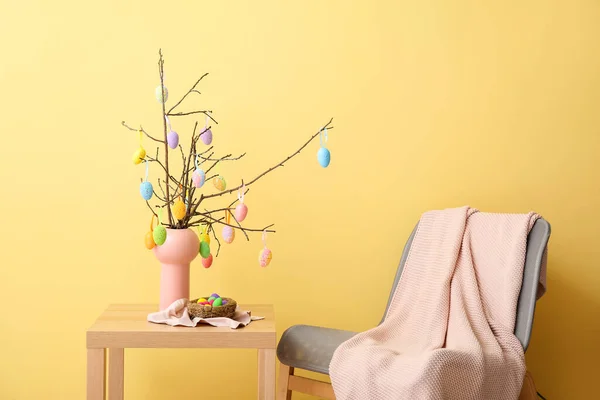 Vaas Met Boomtakken Paaseieren Tafel Fauteuil Bij Kleurwand — Stockfoto