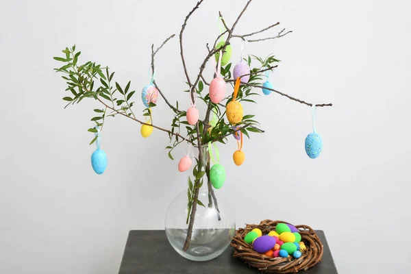 Vase Mit Ästen Und Nest Mit Verschiedenen Ostereiern Auf Tisch — Stockfoto