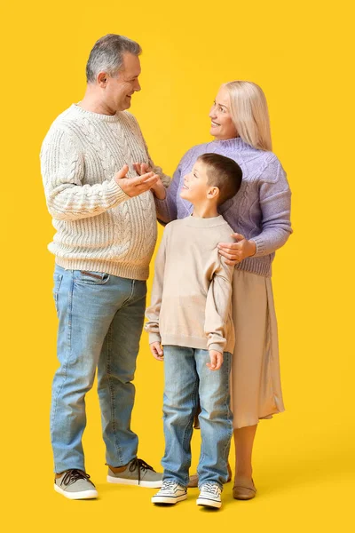 Kleine Jongen Met Zijn Grootouders Warme Truien Gele Achtergrond — Stockfoto