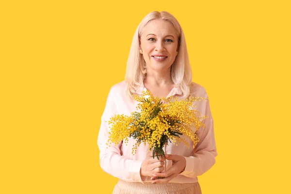Volwassen Vrouw Met Mimosa Bloemen Gele Achtergrond Internationale Vrouwendag — Stockfoto