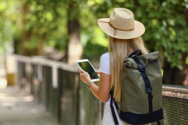 Zoolojik bahçede tablet bilgisayarı olan kadın turist.