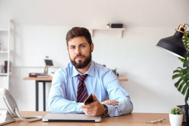 Yakışıklı genç iş adamı ofiste görüntülü sohbet yapıyor.