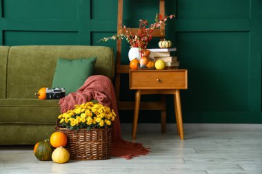 Kanepesi, masası ve sonbahar dekoru olan güzel bir oturma odası.