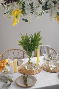 Yemek odasında güzel çiçekler olan şık bir masa.