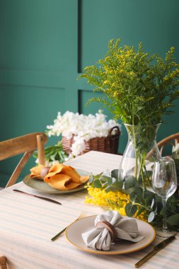 Yeşil duvarın yanında güzel bir sofra.