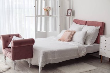 Modern yatak odasının içinde şık bir katlama perde ve kanepe var.