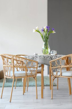 Odadaki yemek masasında güzel süsen çiçekleri olan vazo.